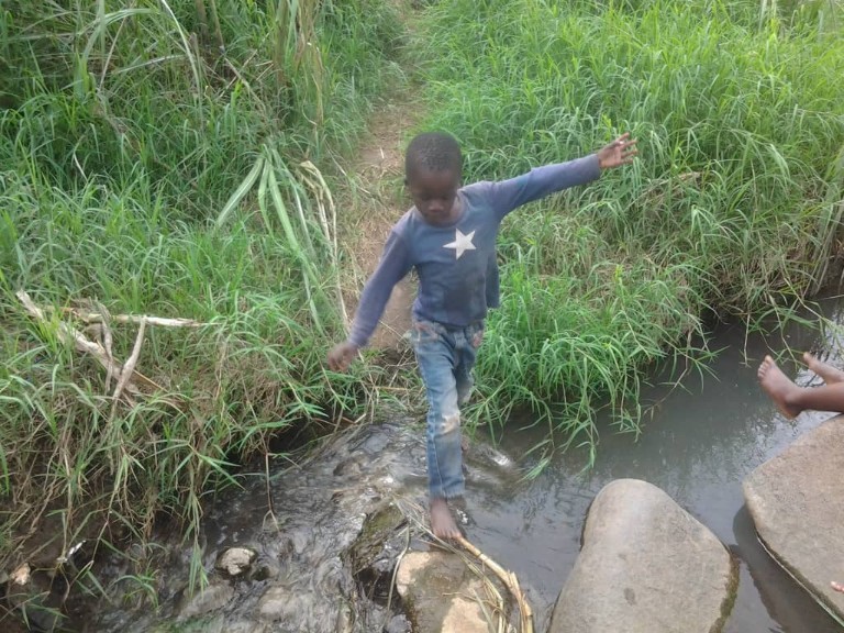 Young boy playing around a burst sewage gutter at Ward 17 Hobhouse, Mutare, Zimbabwe